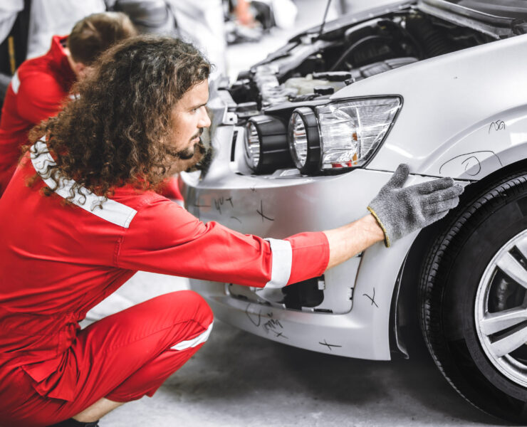 Mechanic garage auto workshop team working service repair fix damaged front bumper accident car