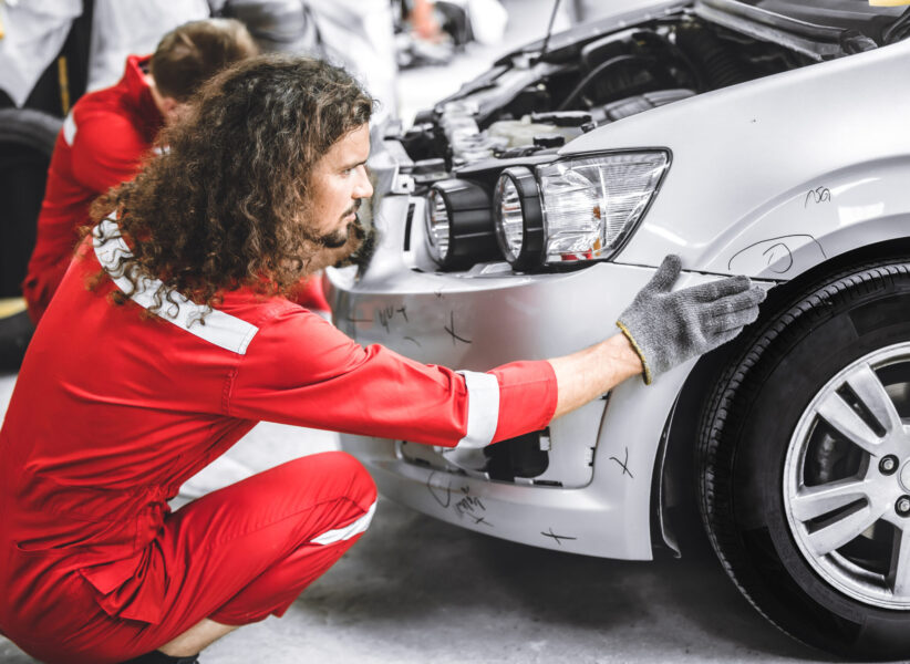 Mechanic garage auto workshop team working service repair fix damaged front bumper accident car